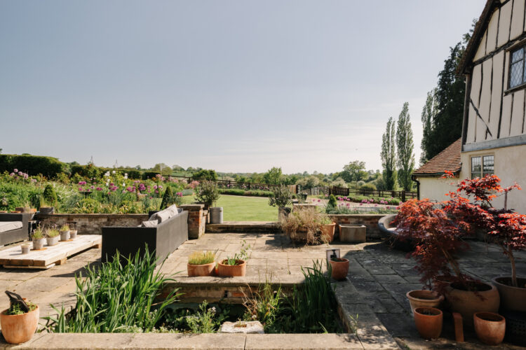 Looking out from the paved sun terrace over the surrounding gardens
