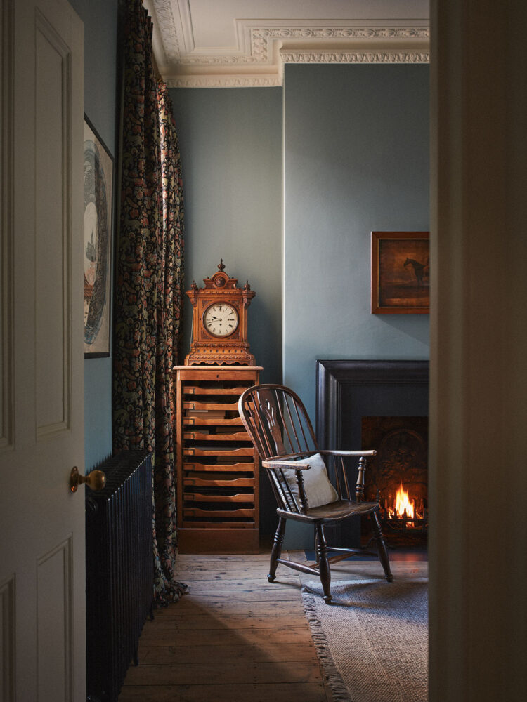 Blue walled living room with fireplace and rocking chair