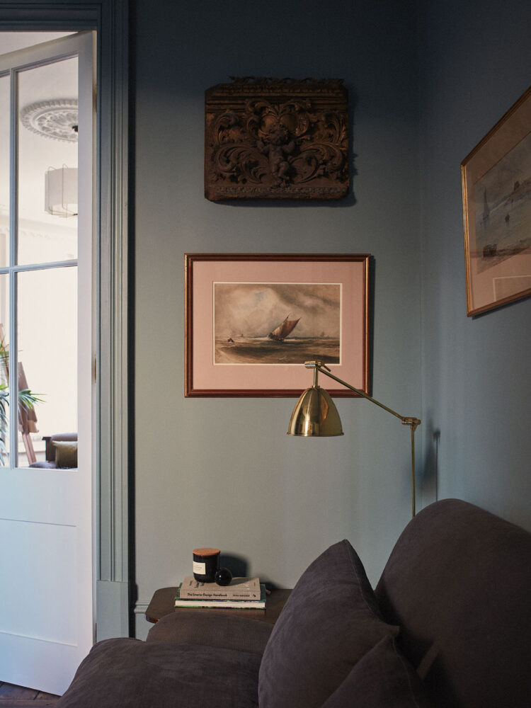 Blue walled living room view of framed artworks
