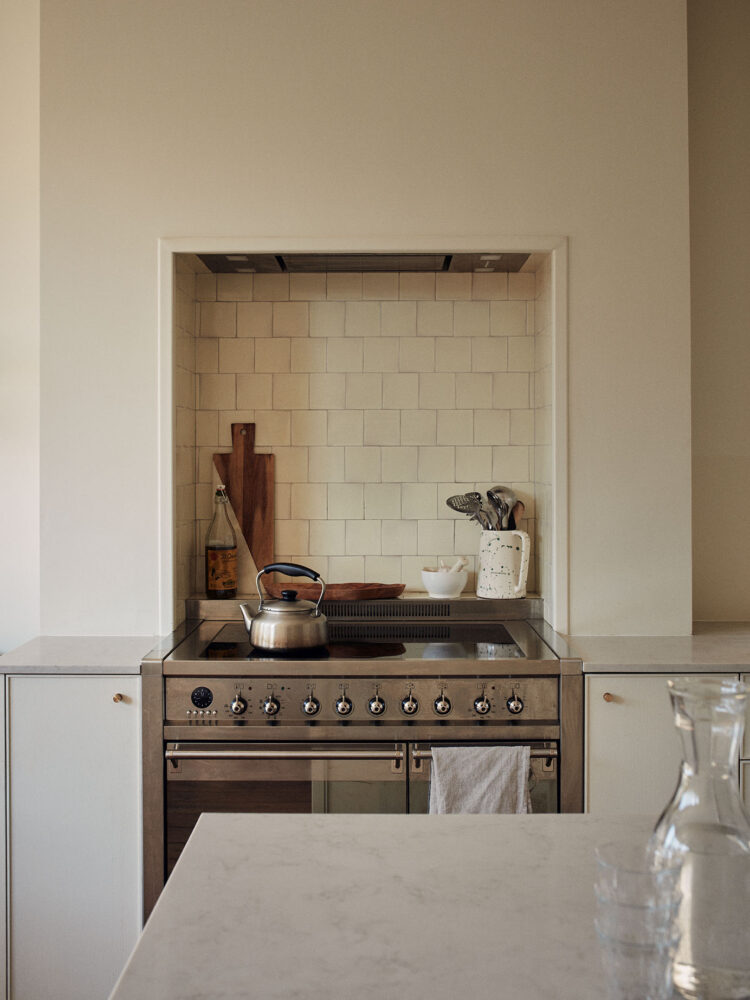 Kitchen stove with tiled splash back and utensils