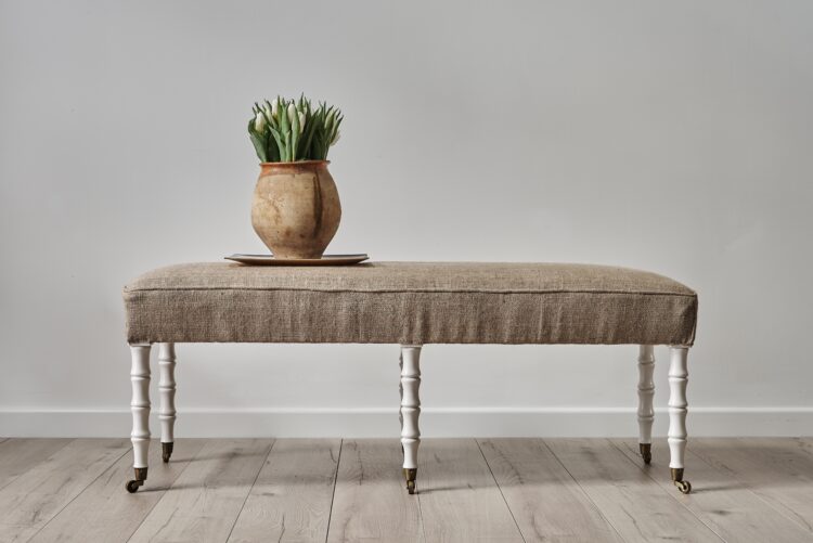 Ottoman with upholstered seat and faux bamboo legs