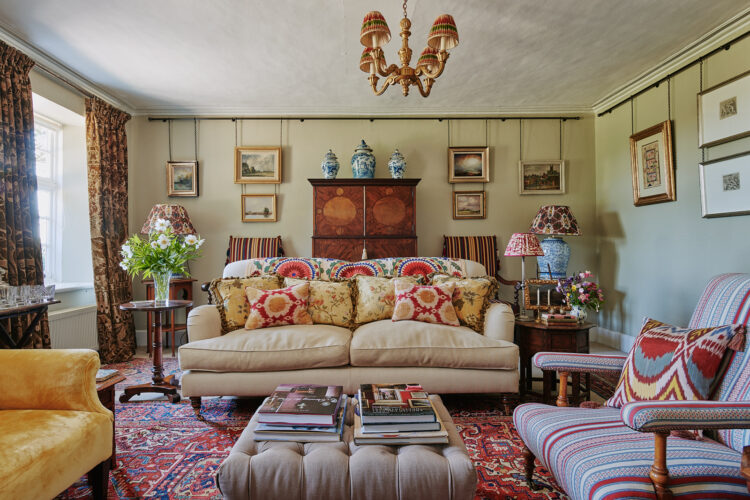 Living room with beige sofa, striped chairs and Turkish rug