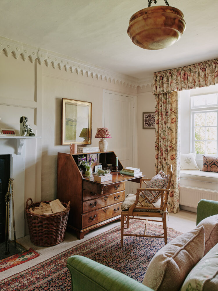 Bedroom with floral curtains with wooden desk and chair