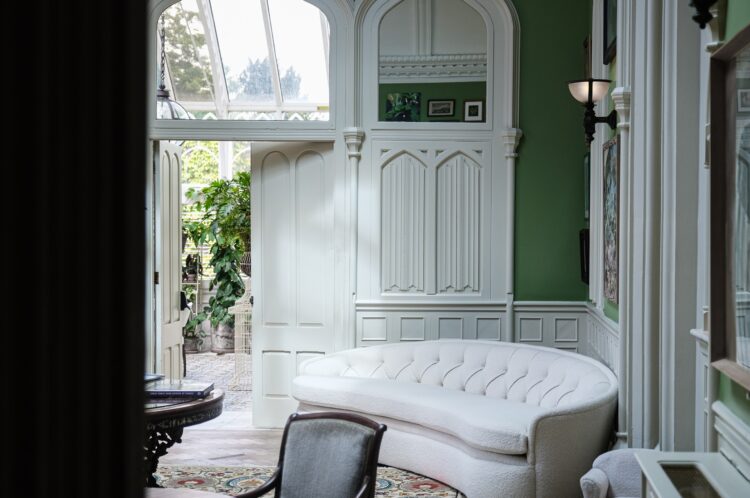 Sitting room with curved white couch and green walls